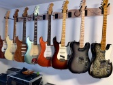 8 guitars hanging from wall