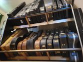 looking up at a two tier shelf system holding guitar cases