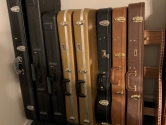 different colored guitar cases in a wood rack