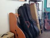 amplifier next to guitar case rack