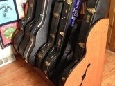 guitar and banjo cases in a wood stand
