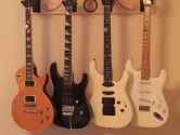 electric guitar hanger with 4 instruments affixed to the wall