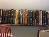 a wall lined with guitar cases, with a red chair in the foreground