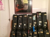guitar cases neatly aligned below a poster of Martin Guitars