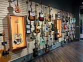 retail store with guitars hanging from the walls and a white telecaster in a display case