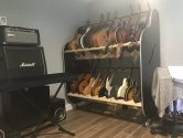 shelves filled with guitars, next to a marshall amplifier