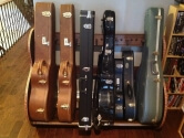 different sized guitar cases in a wood holder