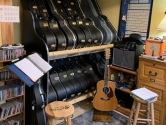 music room with guitars, CDS, amplifiers and sheet music stand