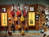 electric guitars in display cases and hanging from the walls of a retail store