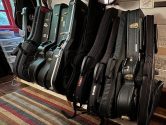 black guitar cases, in a wood frame, on a striped rug