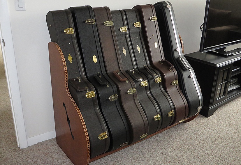 acoustic guitar case rack next to a tv console