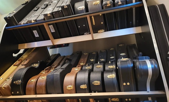 looking up at guitar cases on a shelf